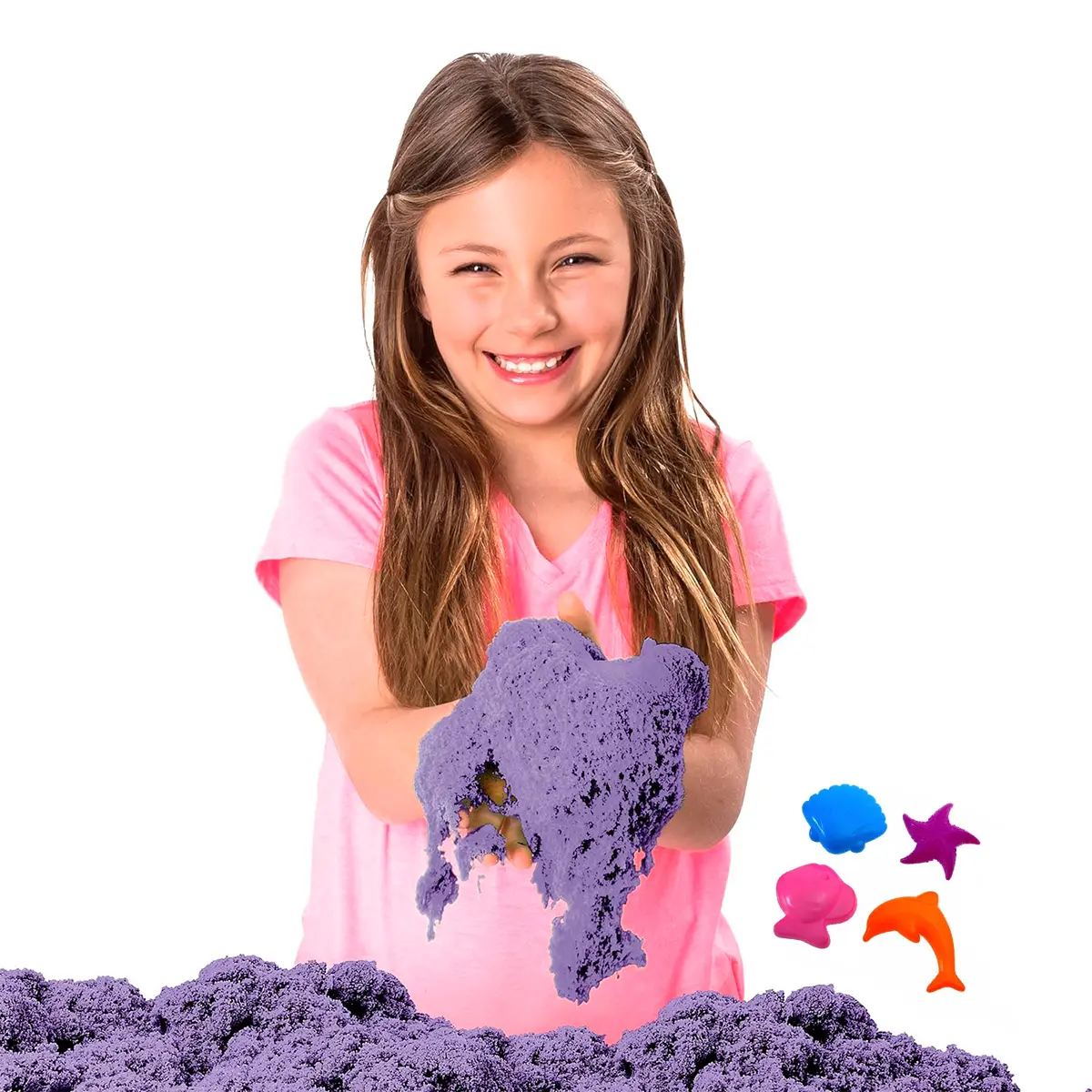 Niña sonriente jugando con arena cinética morada y moldes coloridos.