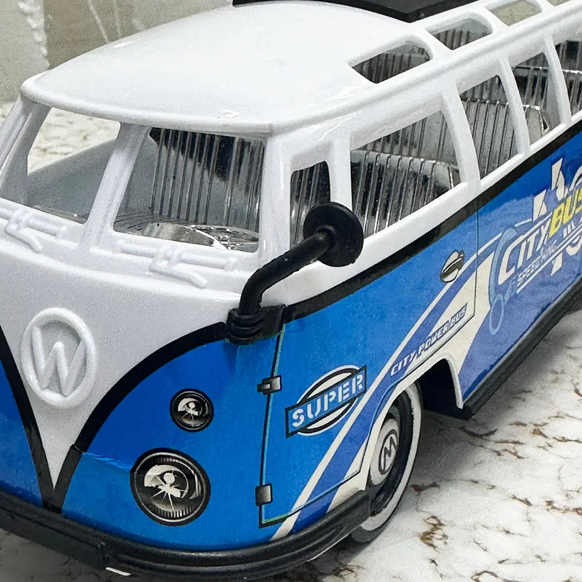 Autobús de juguete azul y blanco con diseño retro deportivo.