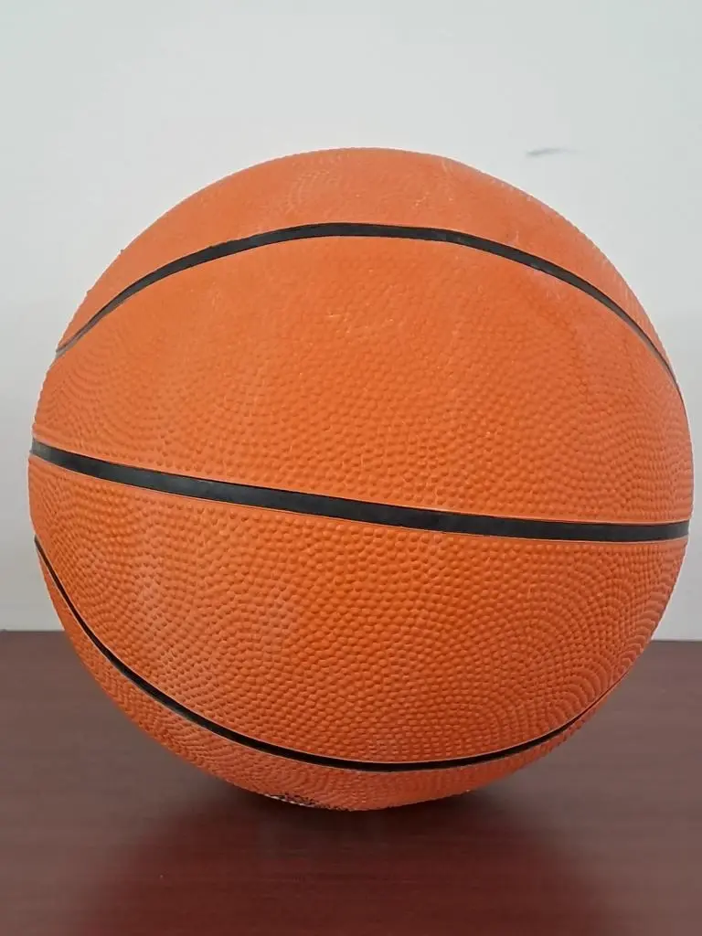 Balón de baloncesto naranja sobre una superficie lisa.