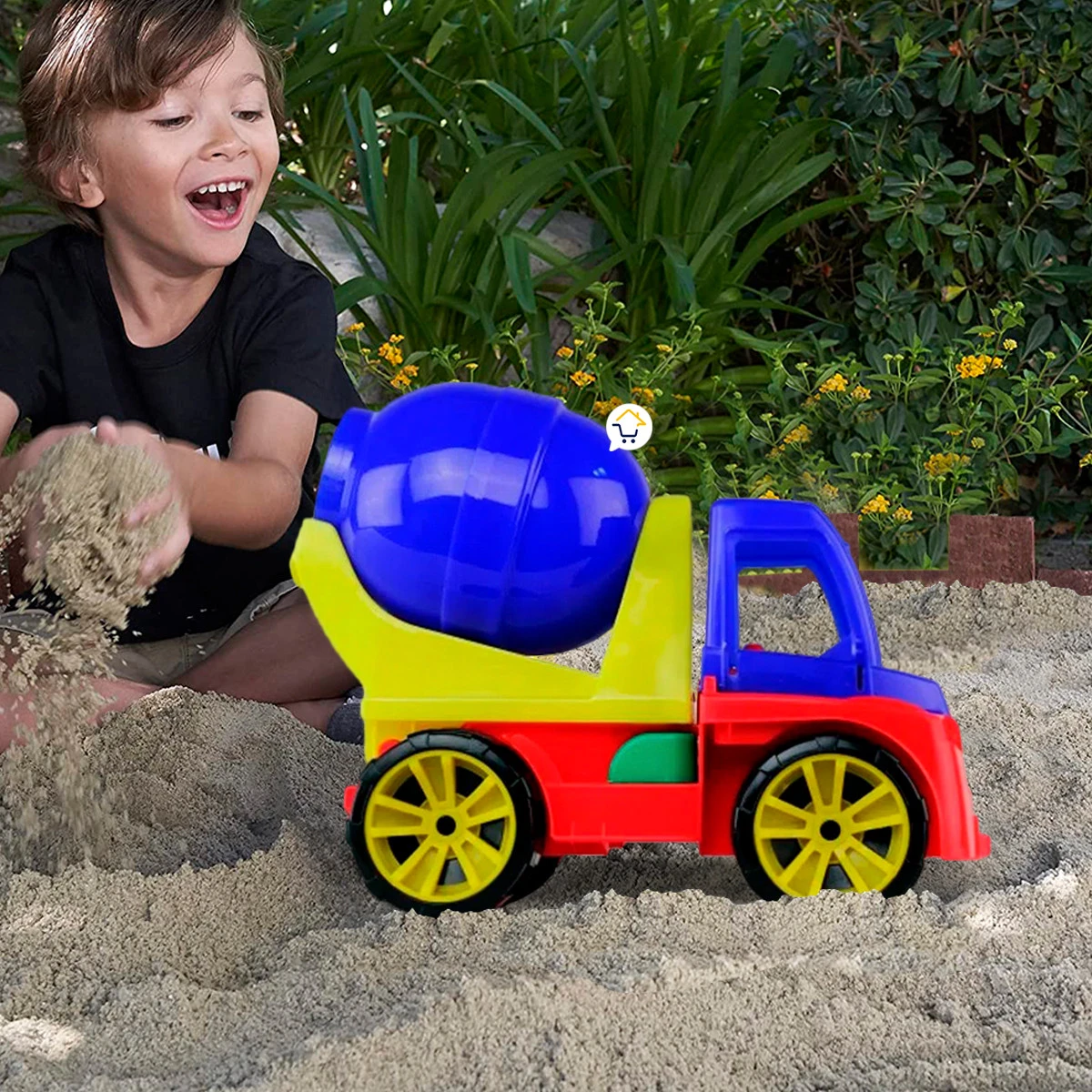 Niño jugando con un camión mezclador de colores en la arena.