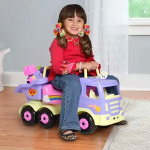 Niña sonriente sobre un camión montable infantil de colores pasteles.