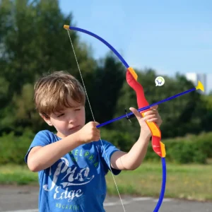 Niño jugando al aire libre con arco y flechas de juguete.