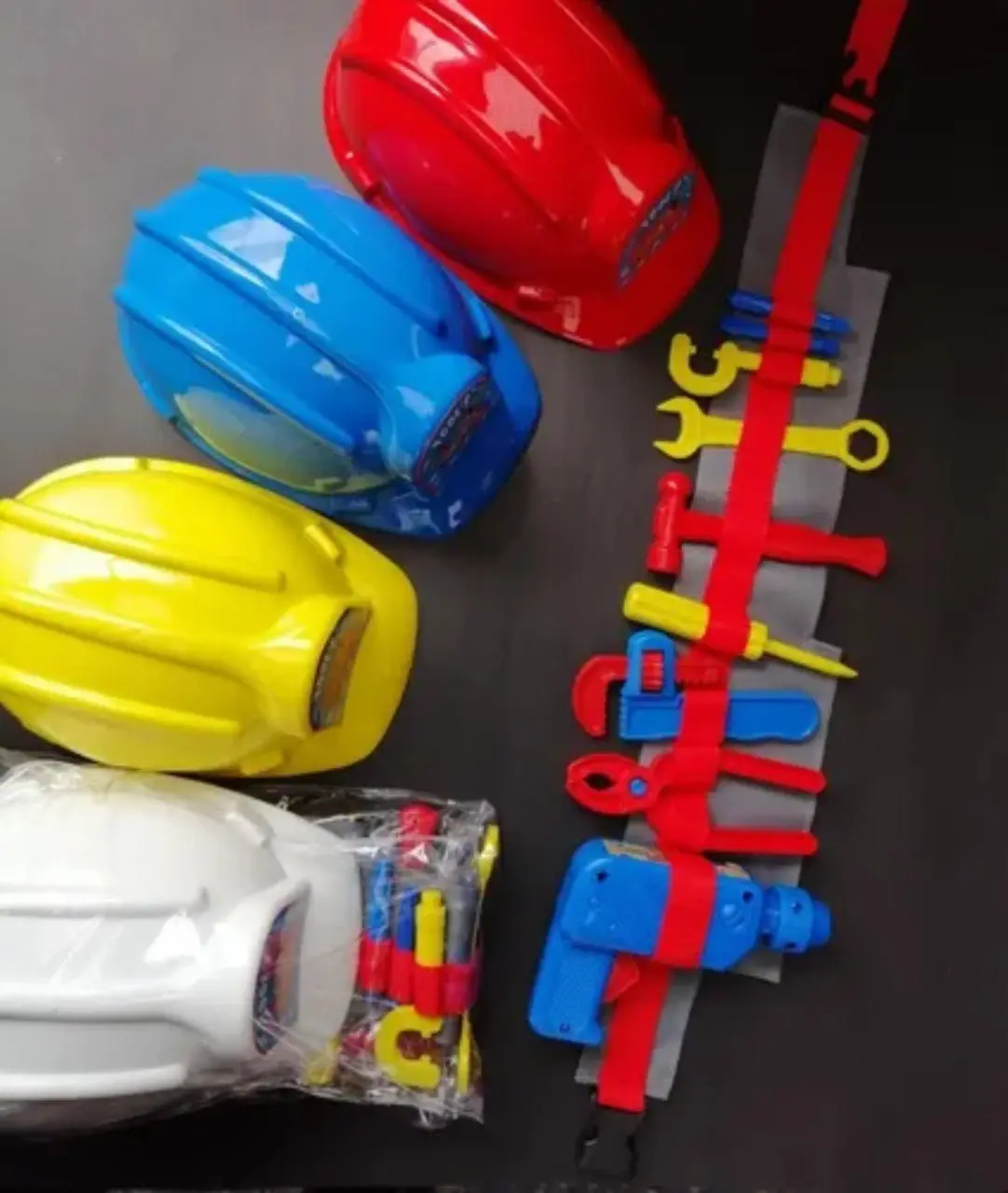 Set de herramientas de juguete con casco y cinturón colorido.