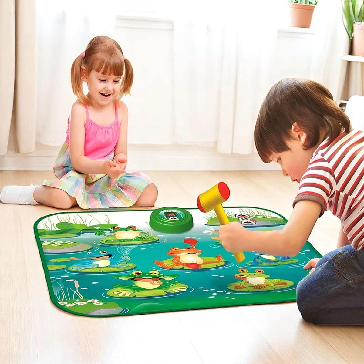 Niño y niña jugando con un tapete interactivo de sapos en una sala.