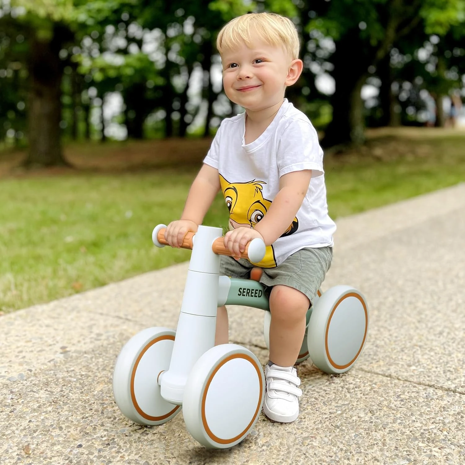 Niño feliz montando una bicicleta de equilibrio SEREED en el parque.