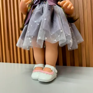 Muñeca con vestido de tul gris con estrellas y zapatos blancos.